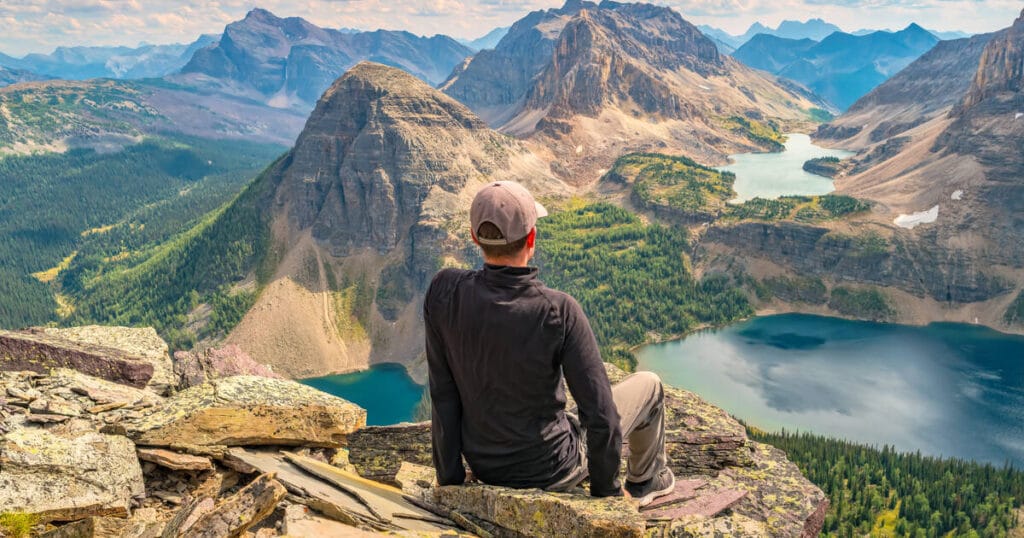 a person sitting on top of the mountain enjoying the views