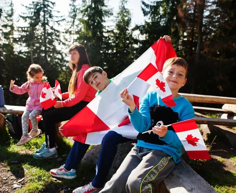 a group of kids waving Canada flags